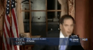 Marco Rubio reaches for a water bottle.